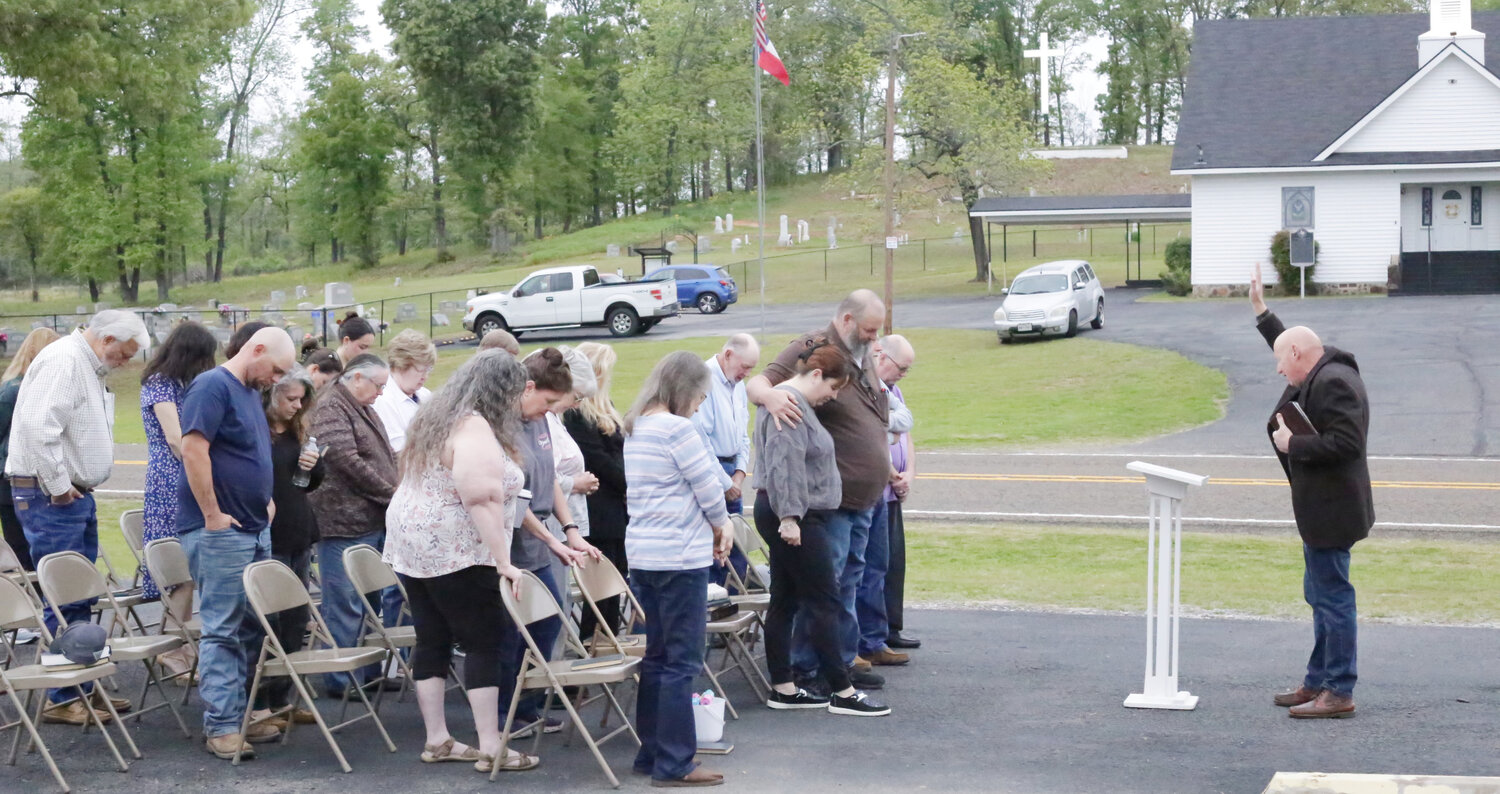 Pastor Michael Phillips leads the Easter sunrise service at Little Mound Baptist as the illuminated cross stands sentinel on the hill above the church.